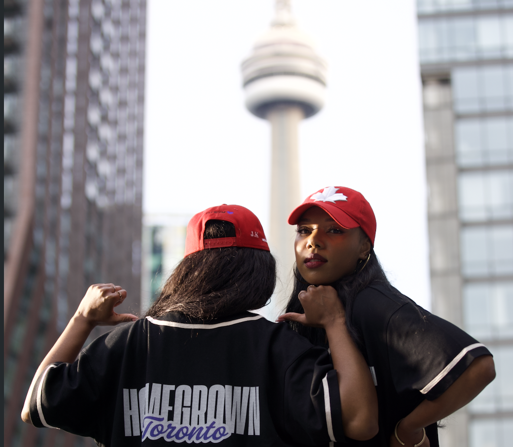 Jayne Kamara and Shawna Stewart in Homegrown Toronto jerseys in front of the CN Tower